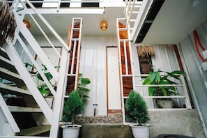 Un escalier avec des rampes blanches et une porte en haut.