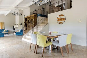 A spacious living area with a dining table, chairs, a staircase, and a chandelier. - Luxury Villa in Provence in the Verdon Regional Park and Among Lavender Fields (allemagne en provence)