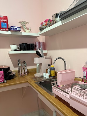 A kitchen with a sink, a coffee maker, and various kitchen utensils. - Girls Night Out Downtown New Orleans (New Orleans)
