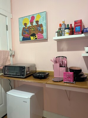 A kitchenette with a toaster, a rice cooker, a coffee maker, and a painting on the wall. - Girls Night Out Downtown New Orleans (New Orleans)