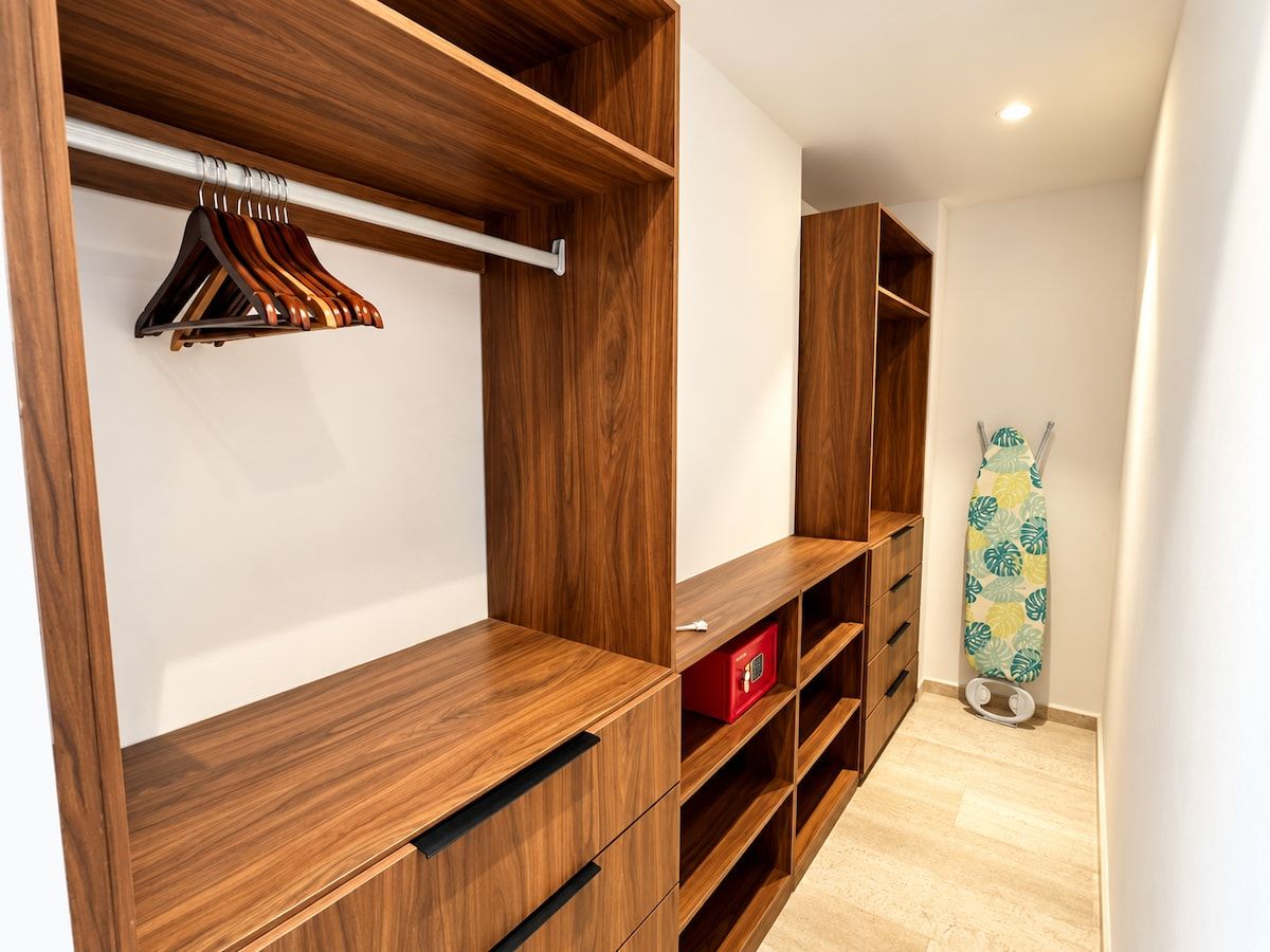 Ein begehbarer Kleiderschrank mit Holzregalen und einer Kleiderstange.