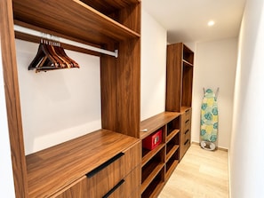 Ein begehbarer Kleiderschrank mit Holzregalen und einer Kleiderstange.