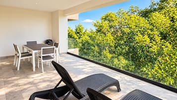 Un balcon avec un ensemble de mobilier de jardin comprenant une table et deux chaises.
