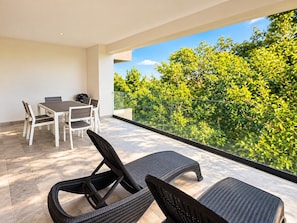Ein Balkon mit Esstisch und zwei Stühlen.