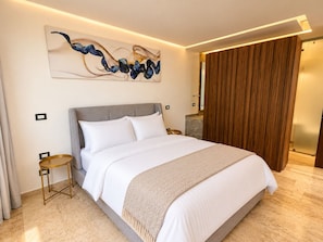 Ein modernes Hotelzimmer mit einem großen Bett, einem kleinen Beistelltisch, einer Wanddekoration und einer Holzwand.