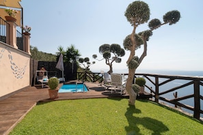 A poolside area with a wooden deck, a small pool, and a view of the sea. - Relais Cacace by Espresso Rentals (Massa Lubrense)