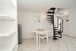 A modern kitchen with white cabinetry, a built-in oven, and a black spiral staircase. - Casa Melina by Espresso Rentals (Sant'Agata Sui Due Golfi)