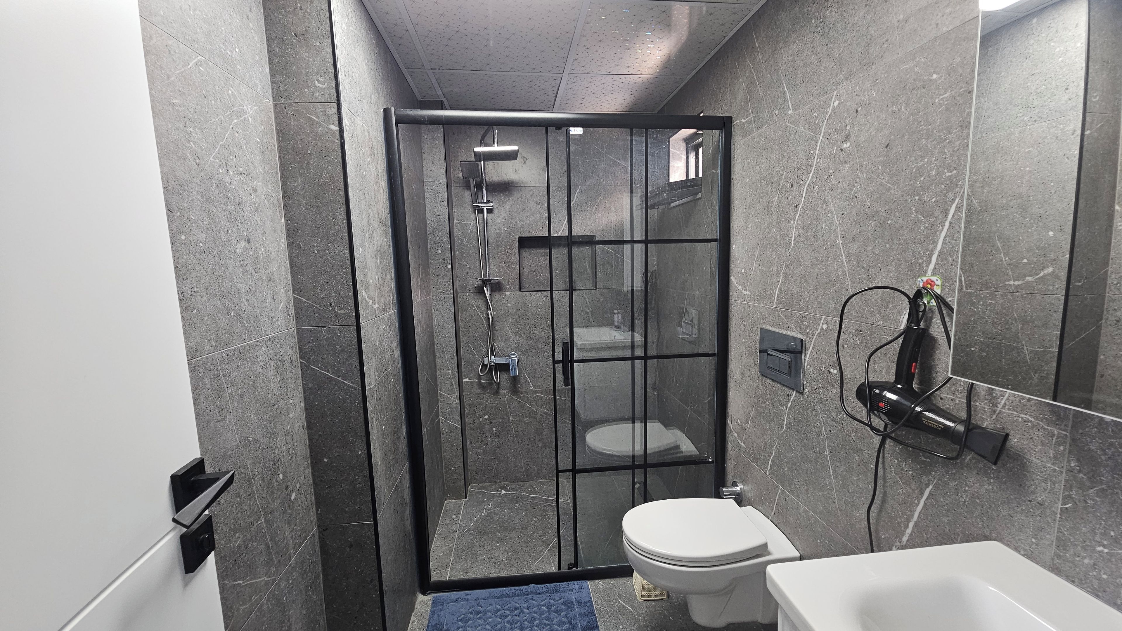 Un baño moderno con ducha envuelta en vidrio, inodoro y bañera.