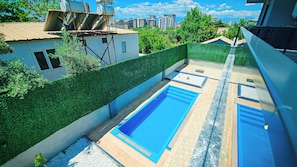 Una piscina en la azotea con vista al paisaje urbano.