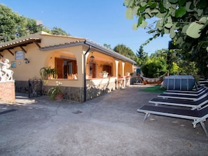 A building with a covered patio area, outdoor seating, and a hammock. - Villa Antolusa by Espresso Rentals (Priora)