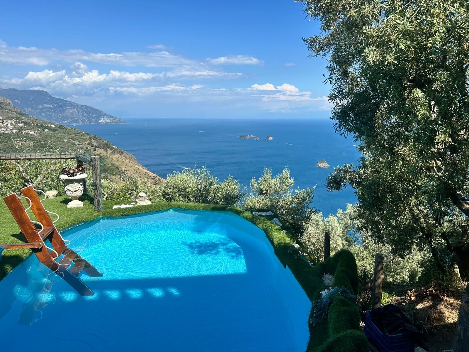 Une piscine avec vue sur la mer et les collines.