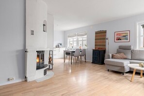 Un salon moderne avec une cheminée, un coin repas et un canapé.