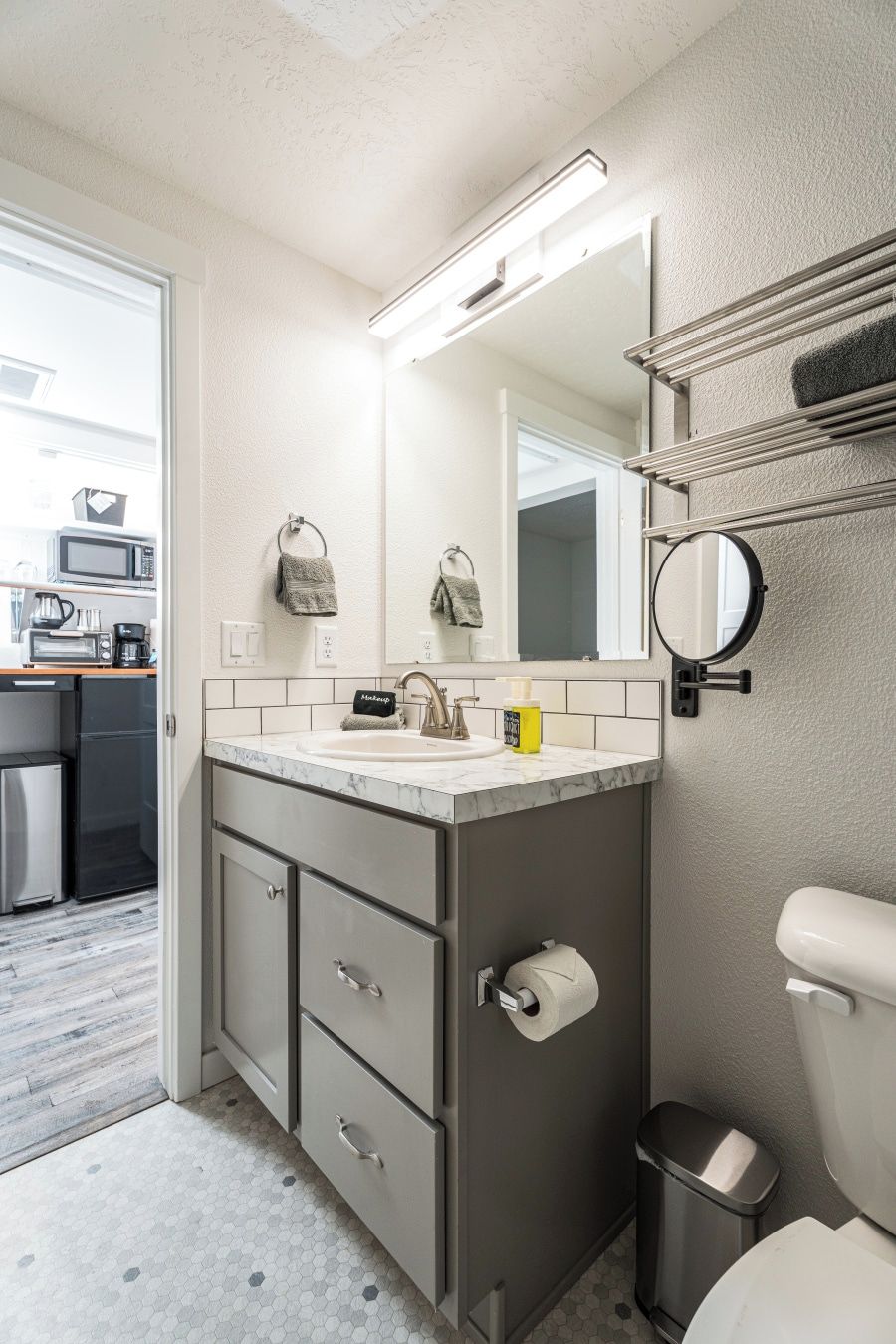 Ein modernes Badezimmer mit Waschbecken, Spiegel und Toilette.