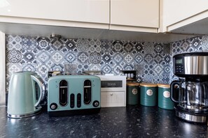 A kitchen with a vintage toaster, a coffee maker, and a kettle on the counter. - Gemstone Diamond - Coop LIVE - Etihad - Free Parking - Pool table (Greater Manchester)