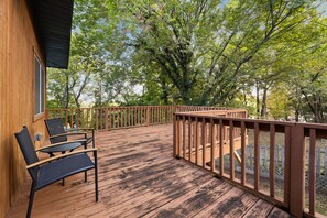 A wooden deck with a railing, two chairs, and a table. - Sunset - 0.8 miles to Razorback Stadium (Fayetteville)