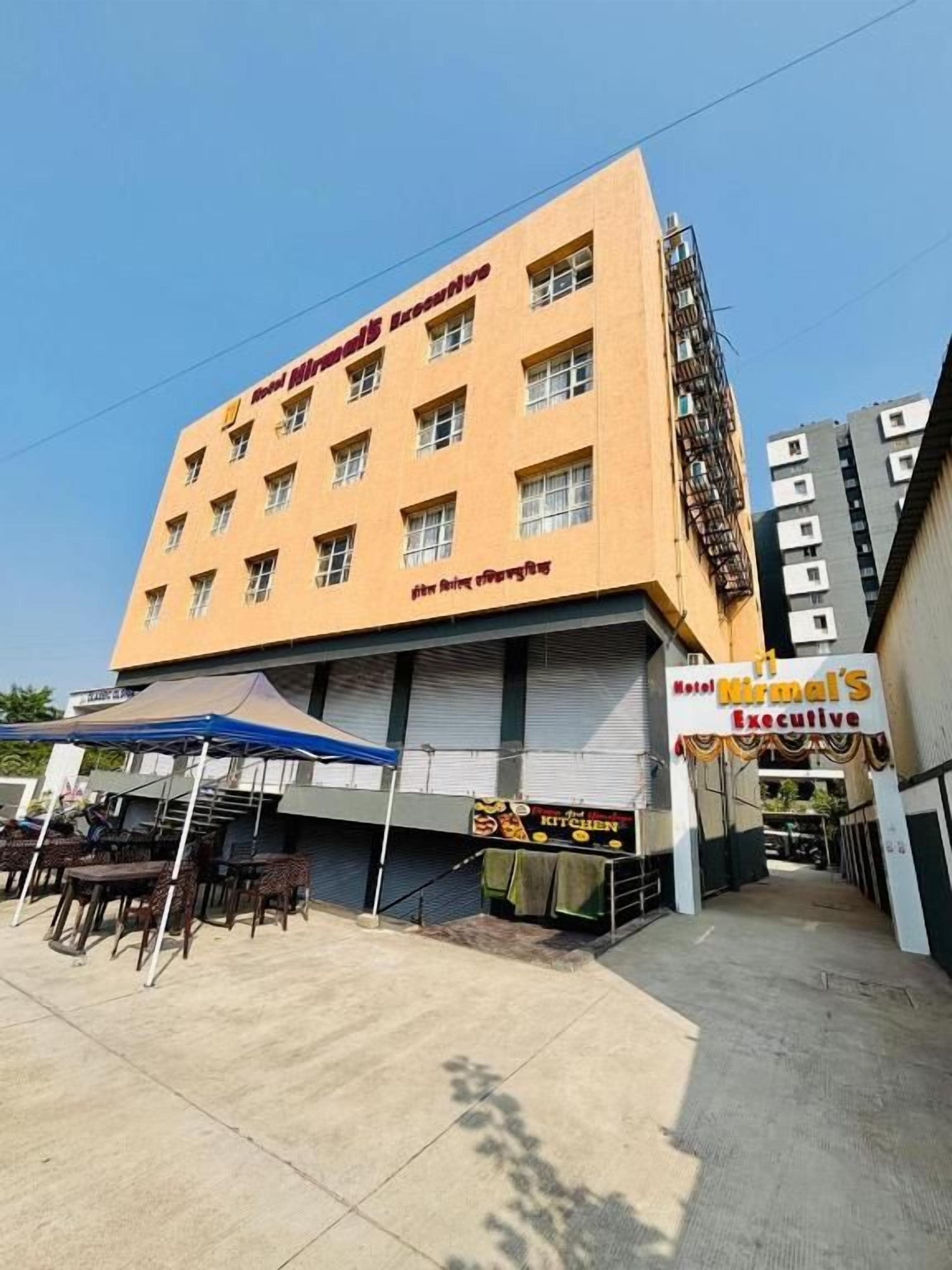 Um hotel com fachada plana, várias janelas e uma placa para a suíte executiva.