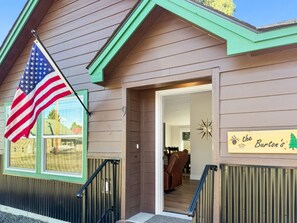 A building with a sign reading 'the Burton's' and an American flag. - Your Mountain Adventure Awaits | Hot Tub + Minutes to Tamarack (Donnelly)