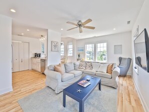 A modern living room with a sectional sofa, a coffee table, and a ceiling fan. - Harbor-View Condo w/ Sun Deck near Cape May (Cape May)