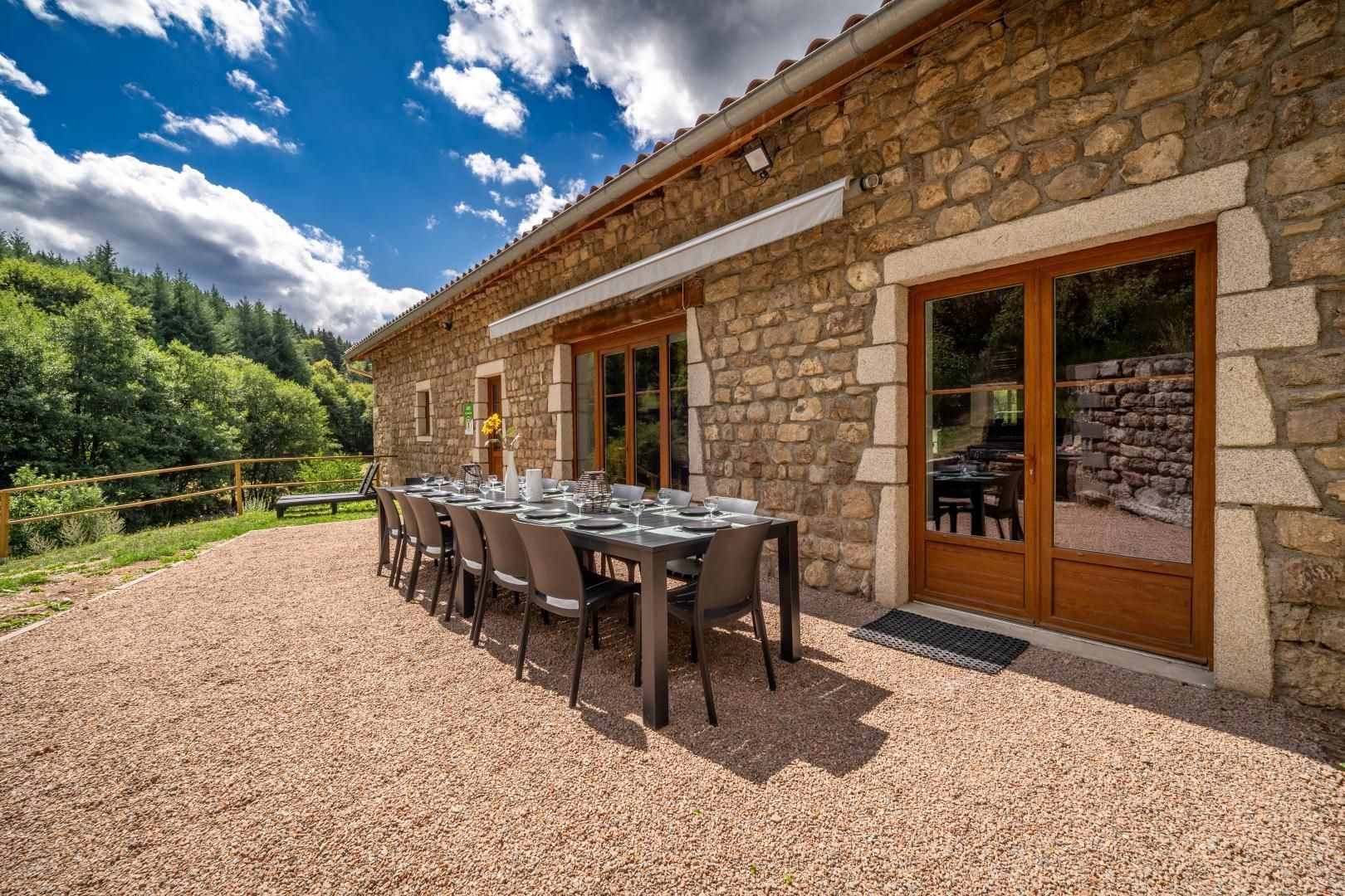 A stone building with a dining area set up outside.