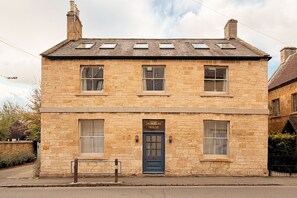 A two-story stone building with a blue door labeled 'Delabere House.' - Entire Home in Moreton-in-Marsh (Moreton-in-Marsh)