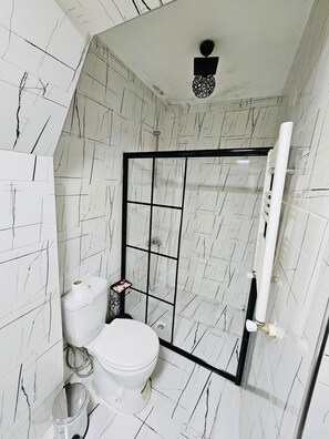 Ein Badezimmer mit Toilette, Duschkabine und Waschbecken.