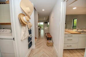 Eine moderne Küche mit weißen Schränken, einer Holz Arbeitsplatte und einem Spülbecken.