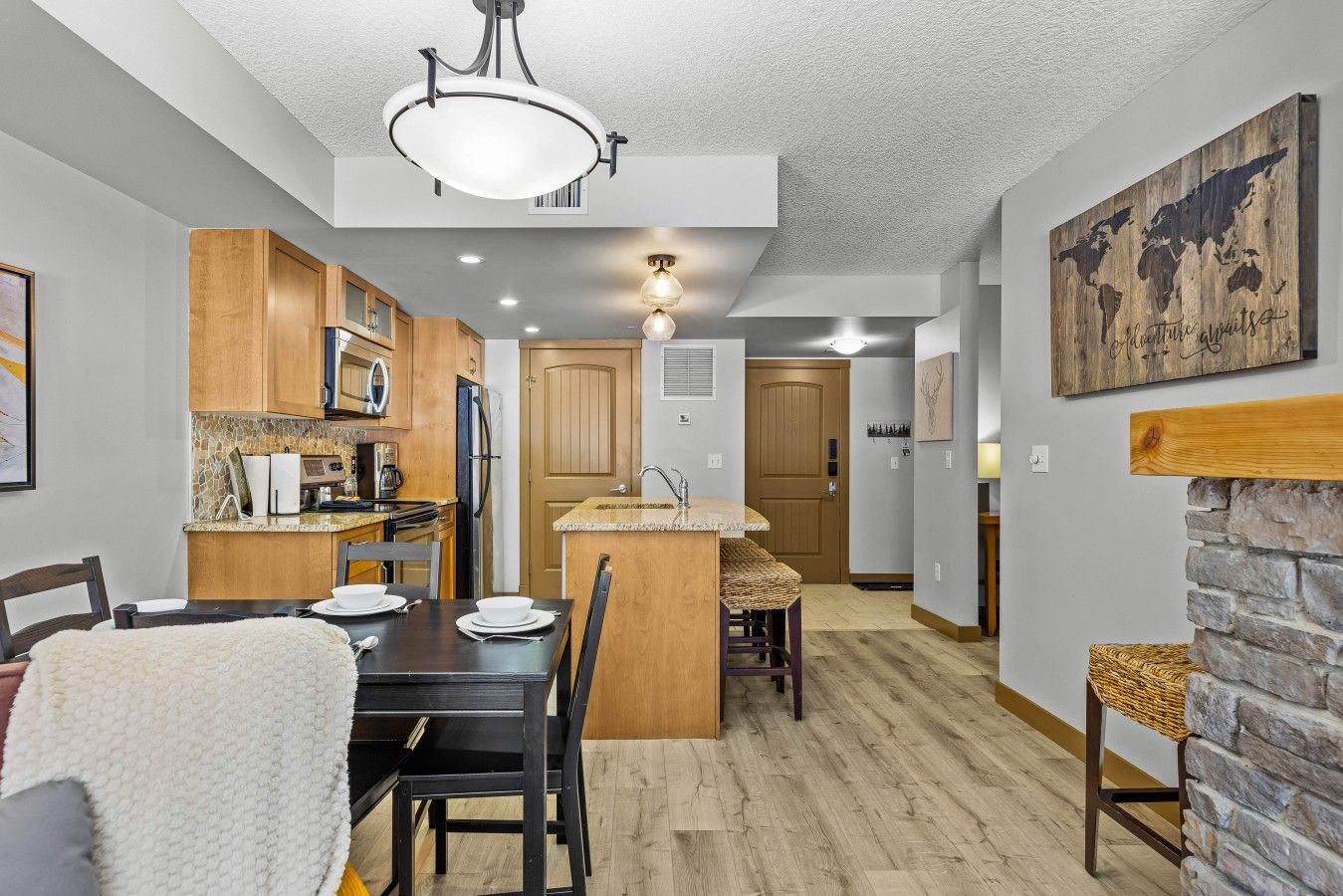 Une cuisine moderne avec des meubles en bois, un îlot central et un coin repas comprenant une table et des chaises.