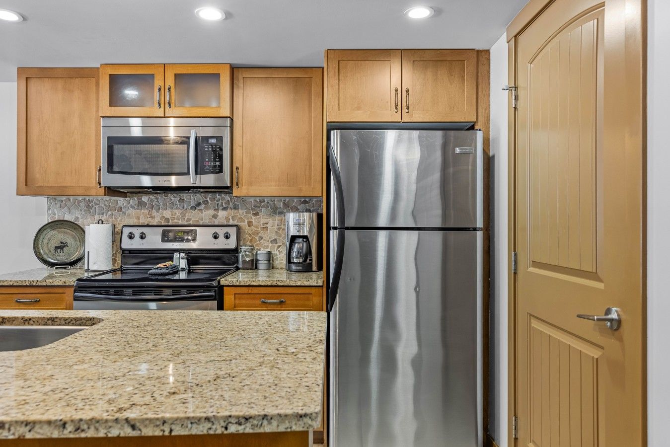 18-stainless-steel-fridge-stove-and-microwave-with-stone-backsplash