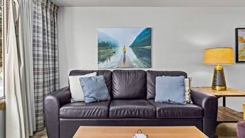31-leather-sofa-with-blue-accent-pillows-and-lake-canvas-art