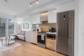 A modern kitchen with a stainless steel refrigerator, oven, and microwave. - Heart of Downtown - 2BR - Near Dundas Square (Toronto)