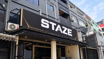 A building with a prominent 'STAZE' sign, featuring a modern architectural style with a flat roof and large windows.