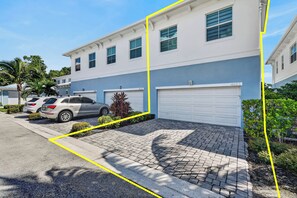 En tvåvånings bostadsbyggnad med ett garage, en uppfart och en parkeringsplats med plats för två bilar.