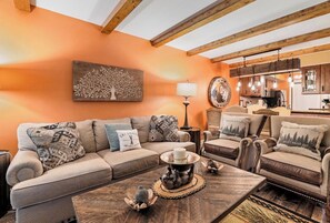 A cozy living room with a sofa, armchairs, and a coffee table. There is a painting on the wall and a lamp on a side table. - Mountain Bear Retreat (Gatlinburg)