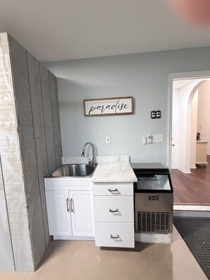 A compact kitchen with a built-in sink, white cabinets, and a countertop. - Luxury Coastal Retreat/Private Pool/Lanai/Fire Pit/ Community Pool (Destin)