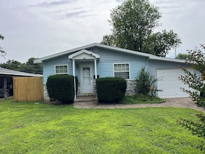 A single-story house with a front door, two windows, and a garage. - Cozy 1-bedroom bungalow in peaceful Springfield with AC (Springfield)
