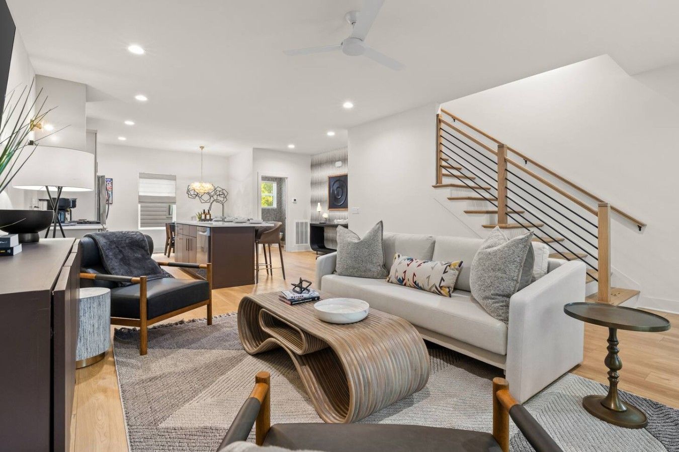 A modern living room with a sofa, coffee table, and a staircase.