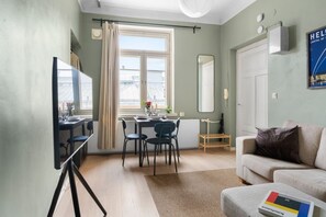 Un salon moderne comprenant un coin repas, un canapé, une table basse et une vue sur la ville.