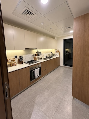 A modern kitchen with a central island, built-in appliances, and a view into the adjacent dining area.