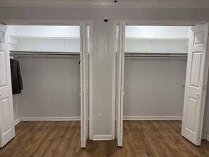 A room with a wooden floor, white walls, and a closet with a hanging rod. - Tremendous 4-bedroom house with all amenities (Kenner)