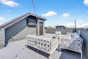 A rooftop patio with outdoor seating and a covered area. - Rooftop with TV & BBQ, Garage, 3 Miles to Broadway (Nashville)