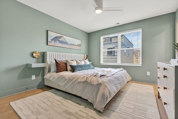 A bedroom with a bed, a window with blinds, a ceiling fan, and a painting on the wall. - Rooftop with TV & BBQ, Garage, 3 Miles to Broadway (Nashville)