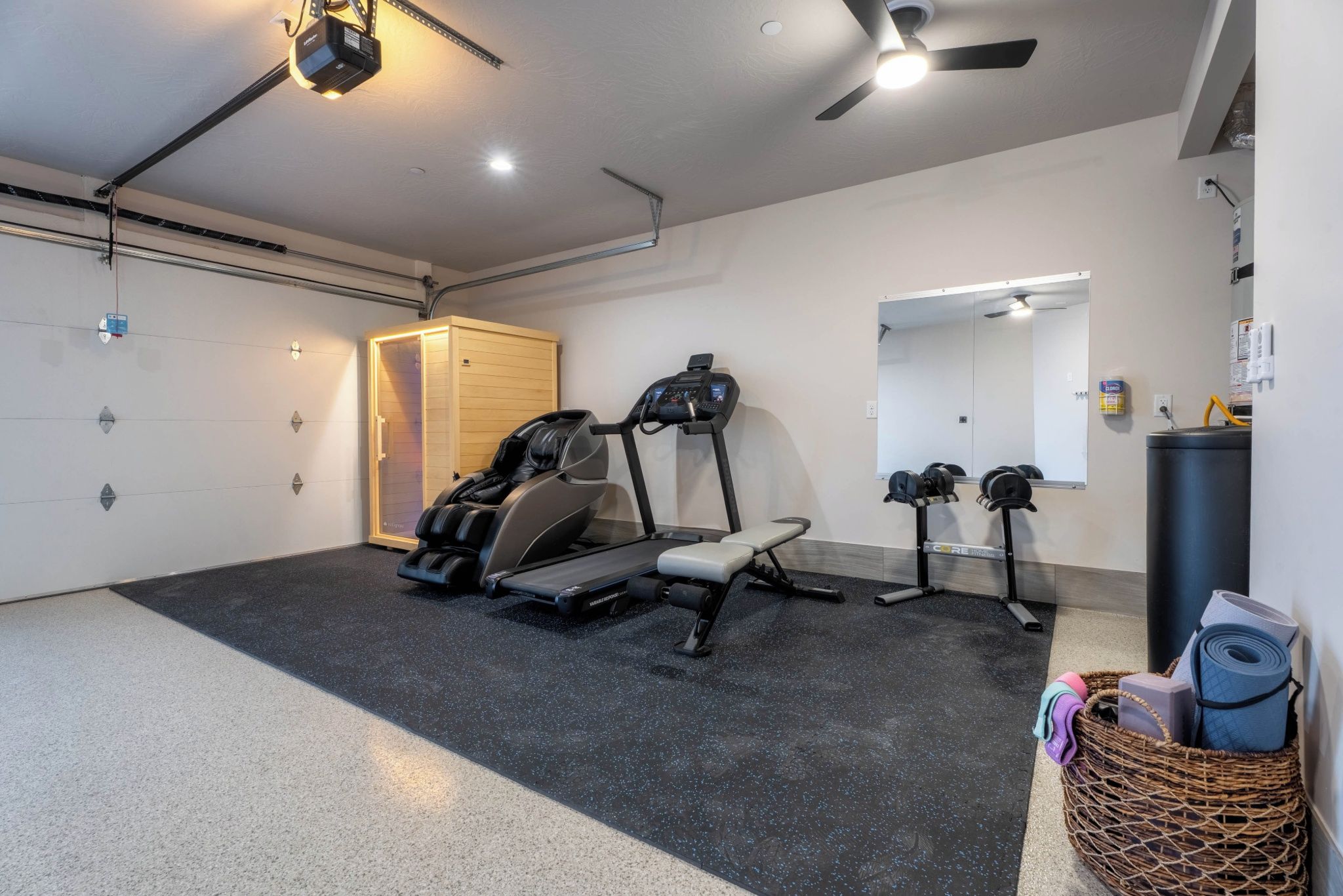 A home gym with a treadmill, stationary bike, and massage chair.