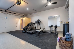 A home gym with a treadmill, stationary bike, and massage chair. - Waterpark View, Steps Away, Sauna + Arcade (Hurricane)