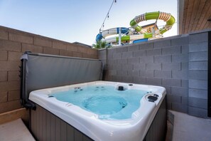 Un jacuzzi con cubierta de madera y pared de ladrillo.