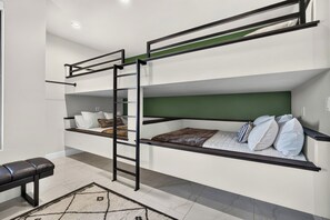 A bunk bed room with a ladder, a bench, and a patterned rug. - Waterpark View, Steps Away, Sauna + Arcade (Hurricane)
