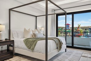 A four-poster bed with a view of a colorful outdoor area. - Waterpark View, Steps Away, Sauna + Arcade (Hurricane)