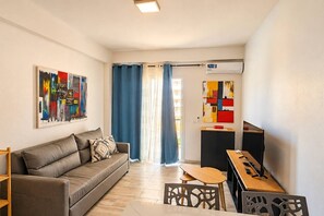 A modern living room with a sofa, a coffee table, and artwork on the walls. - Beachside • Balcony • Estoril Beach • Best Beach (Sal Rei)