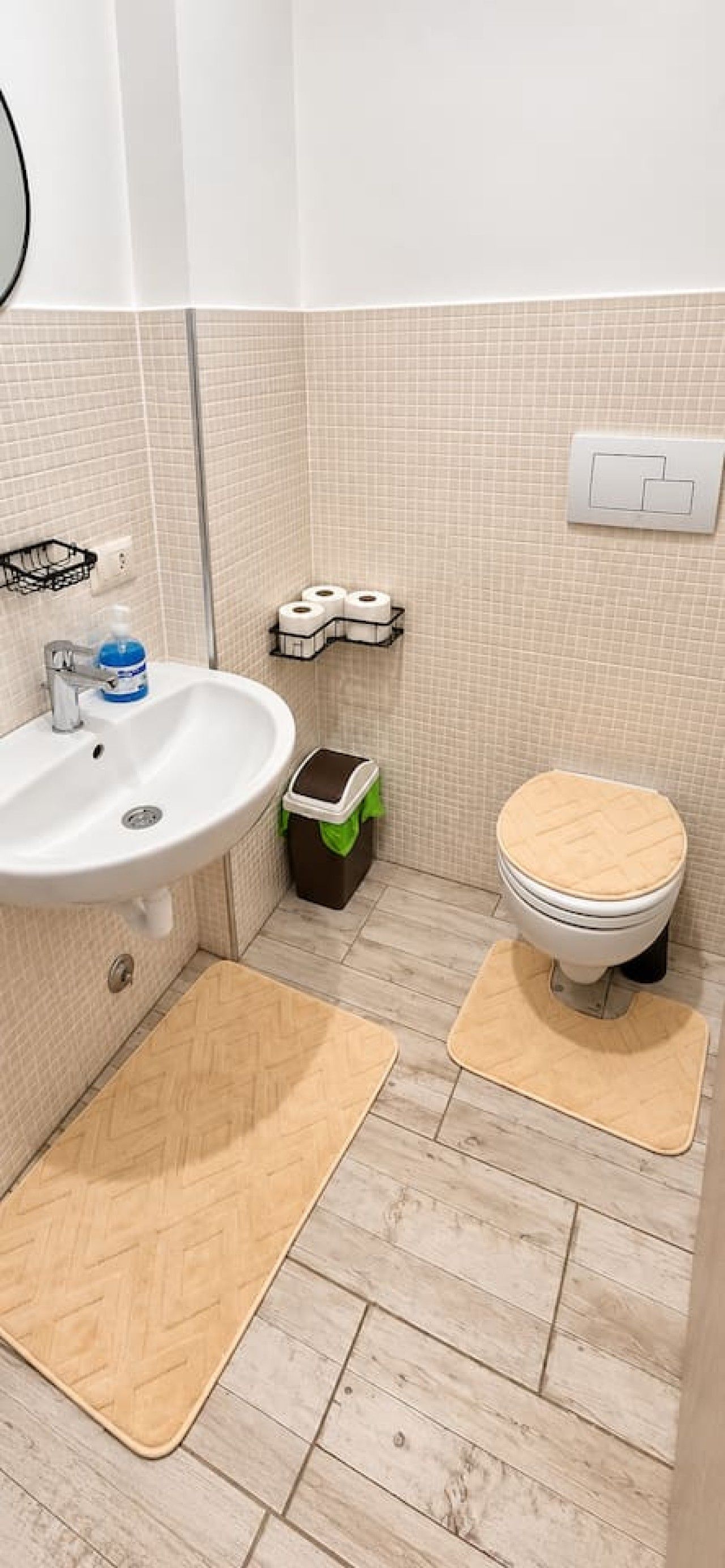 Une salle de bain avec un lavabo, des toilettes et une poubelle.