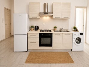 A modern kitchen with a refrigerator, oven, stove, sink, and washing machine. - Insuited Penthouse with Rooftop in Estoril beach (Sal Rei)