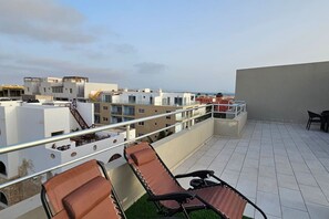 A rooftop terrace with a view of the cityscape, equipped with lounge chairs and a small table. - 3 apartments for up to 14 guests in Estoril beach (Sal Rei)